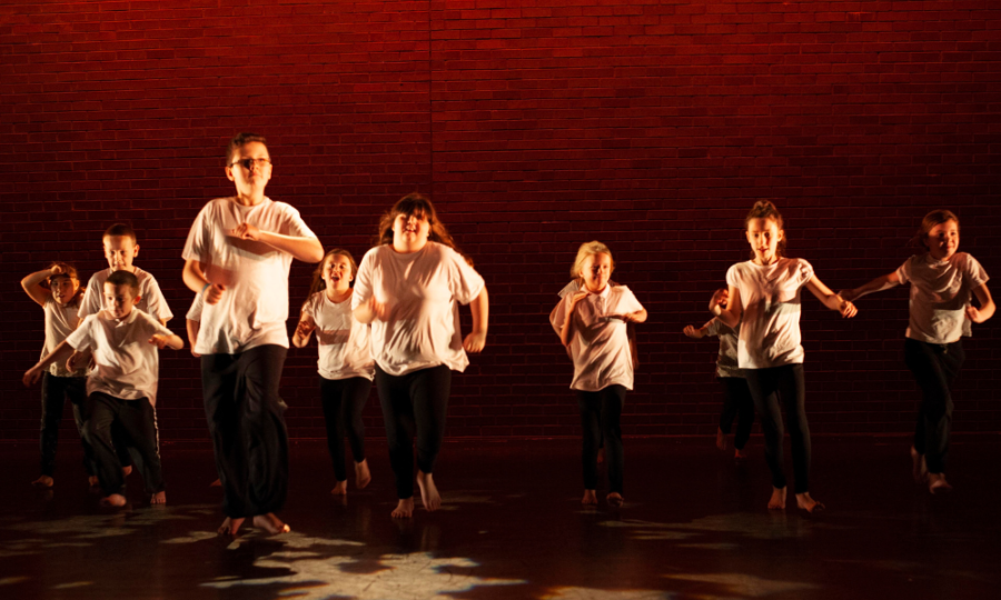 Young performers at Gosforth Civiv Theatre are dancing in a dimly lit theatre
